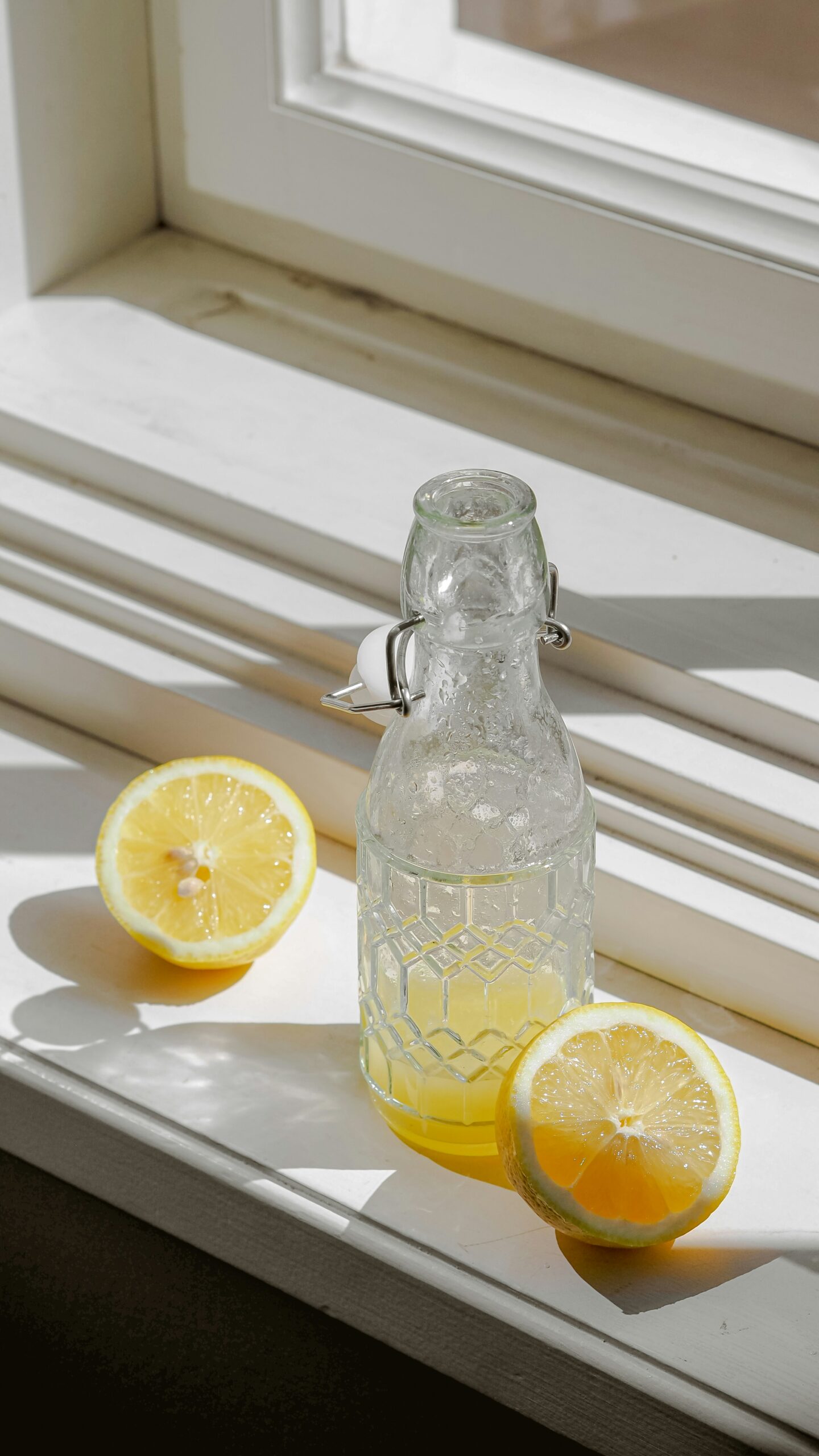 Fresh water bottle with lemon and mint on a table outdoors signifying hydration