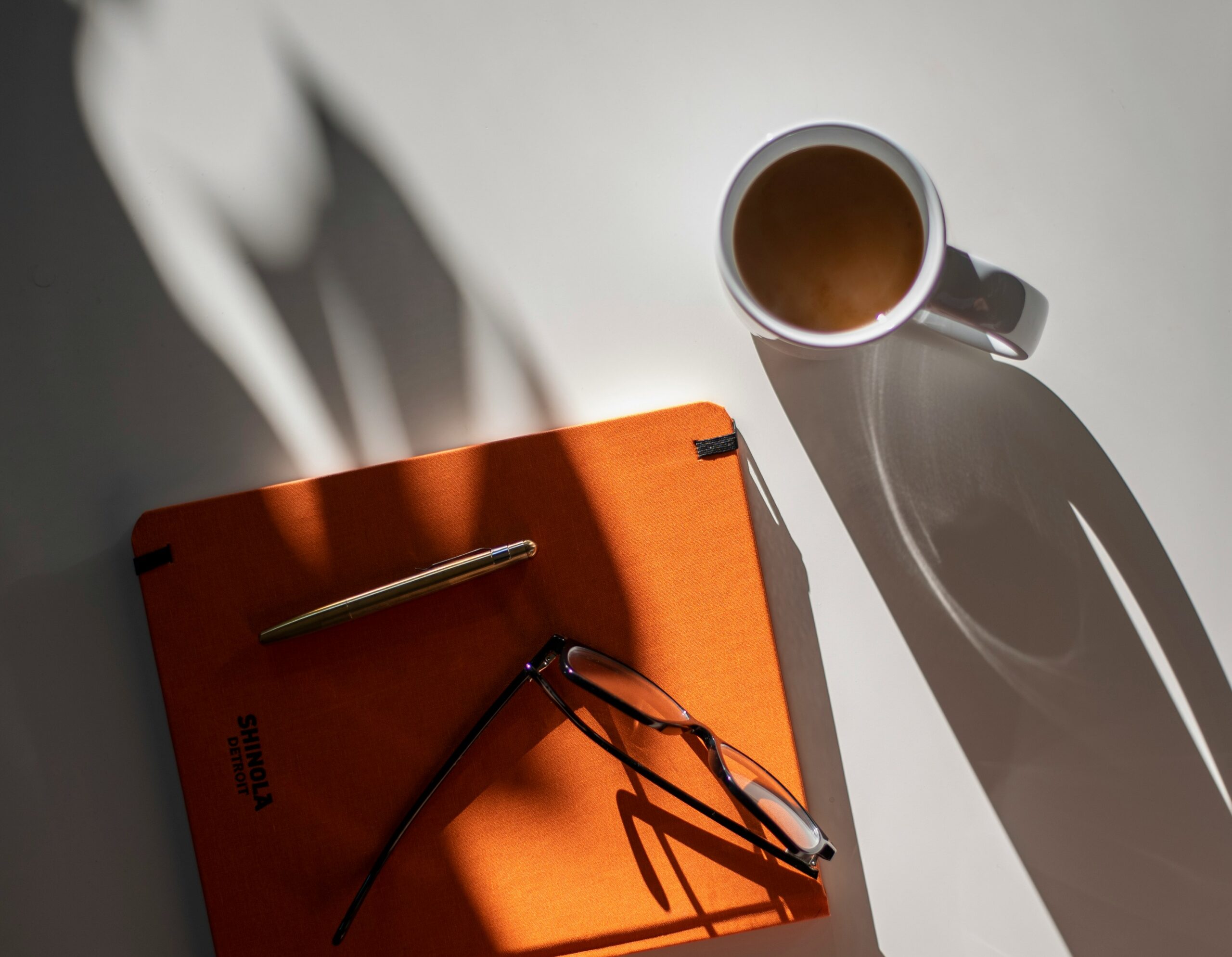 Top view of a desk with a laptop, a notepad, and a cup of Marita coffee, symbolizing productivity