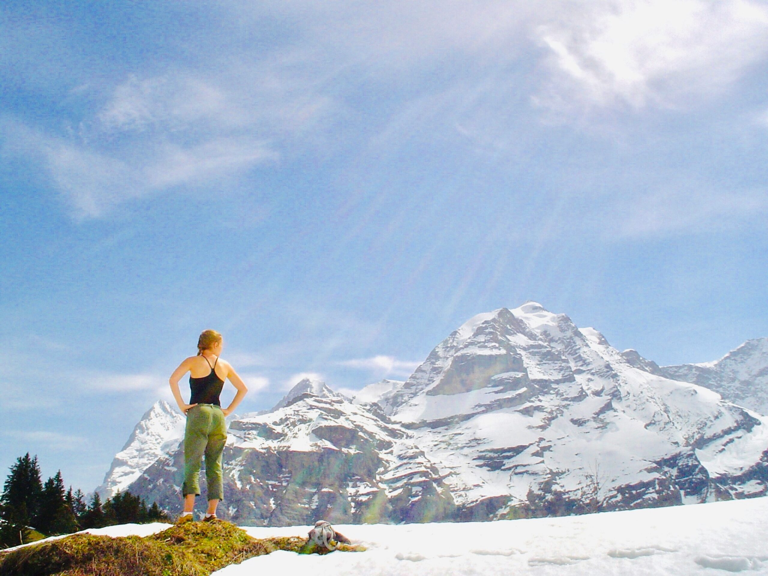 Happy woman hiking in the Swiss mountains, looking energetic and healthy, illustrating the vitality benefits of functional coffee.