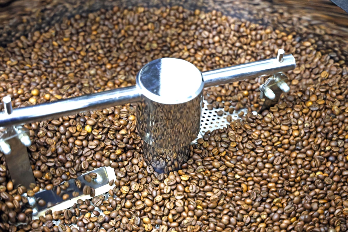 Roasted coffee beans are being stirred in a roaster.
