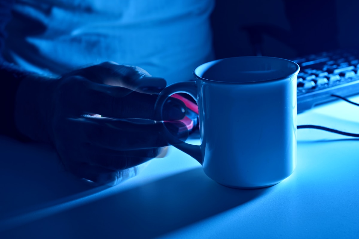 white ceramic mug on blue table